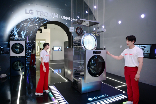 서울 코엑스에서 열리는 월드IT쇼 2024에서 LG전자 모델들이 'LG 시그니처 세탁건조기'의 'AI DD모터'와 '인버터 히트펌프' 등 핵심 부품을 살펴보고 있다. LG전자 제공